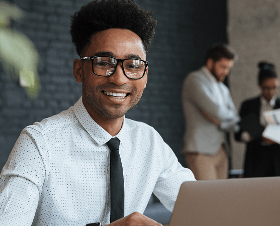 Professional smiling at a laptop in an office