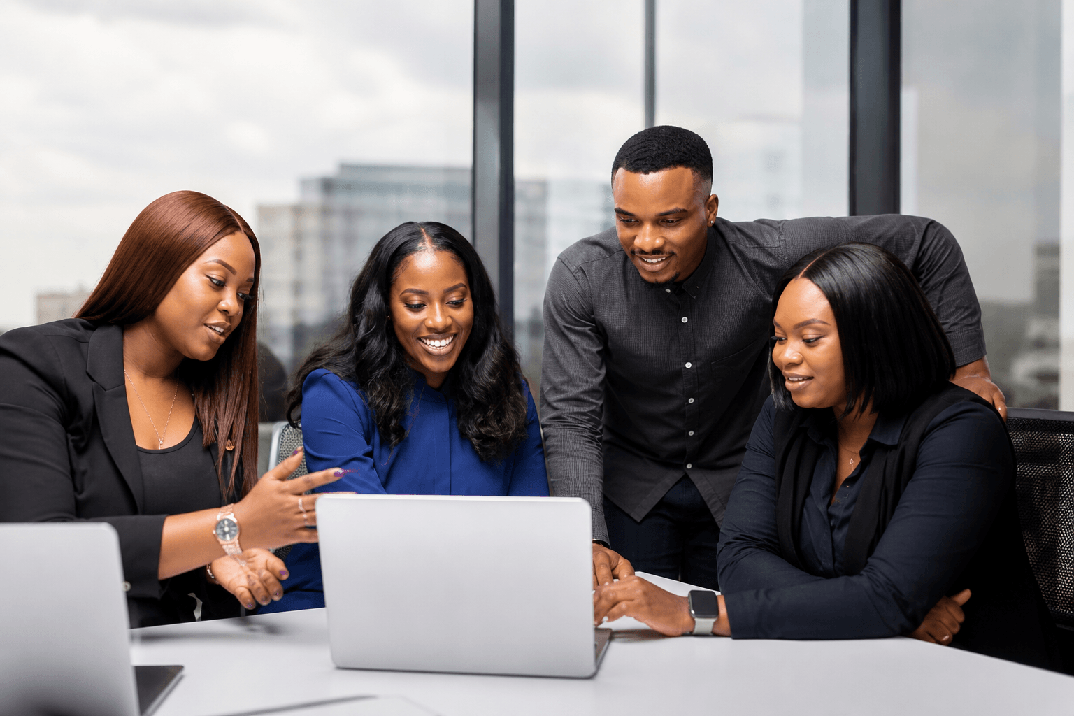 Team of professionals collaborating around a laptop in an office